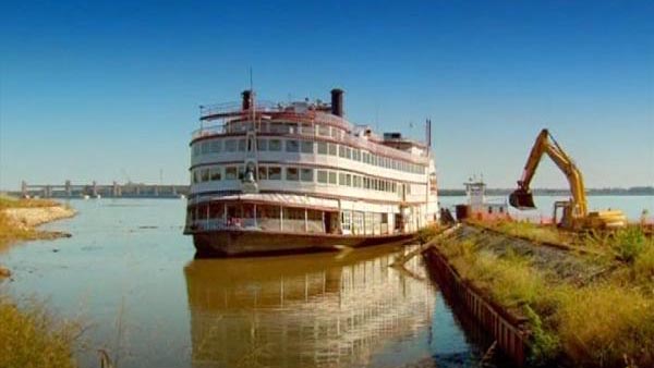 Movers try to drag the Mississippi Steamship President into a dock